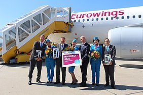 Die Crew und Flughafen Graz Geschäftsführer Widmann vor einem Eurowings-Flugzeug.
