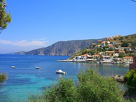 Griechische Bucht mit Booten und weißen Häusern.