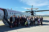 ÖSV-Team mit Hopsi und Gerhard Widmann, dem Geschäftsführer des Flughafen Graz, vor dem Flugzeug.