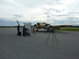Persons at a fotoshooting on the apron in front of a small aircraft
