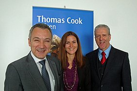 Ioannis Afukatudis, Gudrun Hauser und Gerhard Widmann vor einem Thomas Cook Plakat