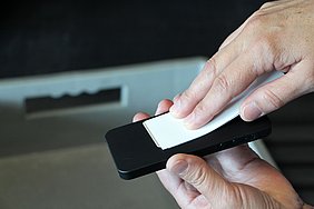 Hand wischt mit weißem Streifen über Smartphone.